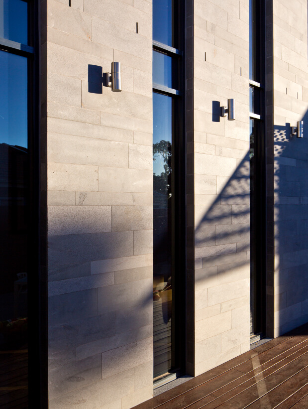 Essendon Residence’s stone outdoor walls with shiny wooden floor